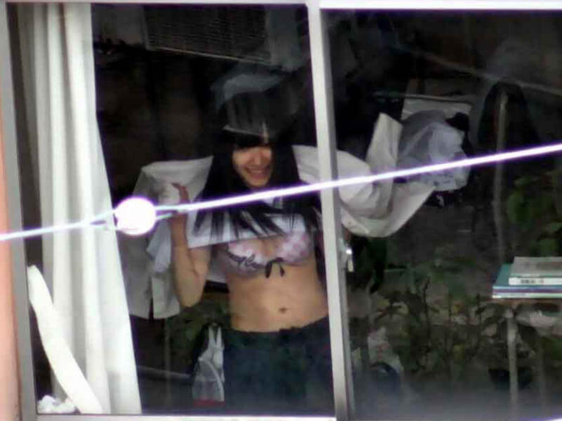 窓際にいる下着女性のエロ画像